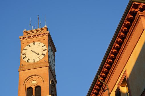 Detail of the civic tower of Forlì in the sunset light, The tower was first built during the Roman empire and modified several times during the centuries, then partially destroyed by the Nazi army in 1944 and rebuilt in 1975.