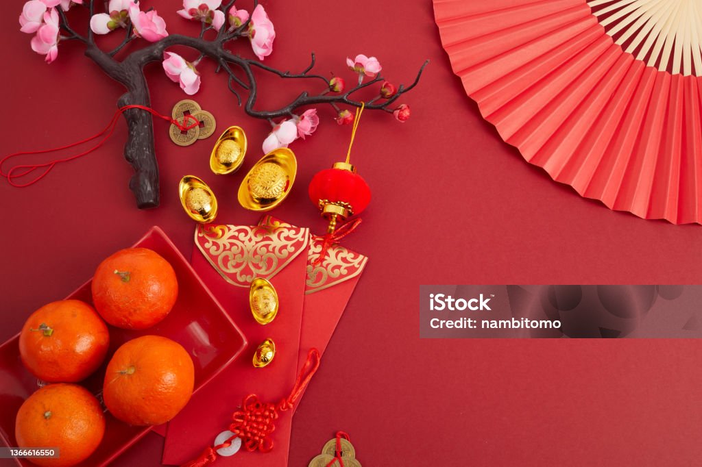 Chinese new year festival decorations. Orange, red packet, plum blossom and lucky money. Translation: let ten thousand wishes come true. Chinese new year festival decorations. Orange, red packet, plum blossom and lucky money on red background. Translation: let ten thousand wishes come true Chinese New Year Stock Photo