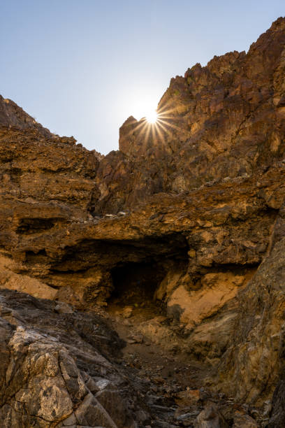 sunburst rompe la cresta rocosa en el valle de la muerte - mojave rattlesnake fotografías e imágenes de stock