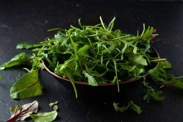 istock Mix salad greens. Arugula, lettuce, spinach in black bowl 1366617824