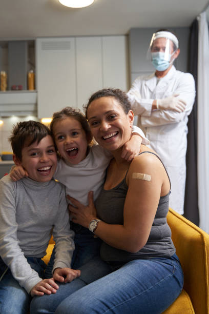happy mother with son and daughter sitting before doctor - boy and girl in kitchen thumbs up bildbanksfoton och bilder