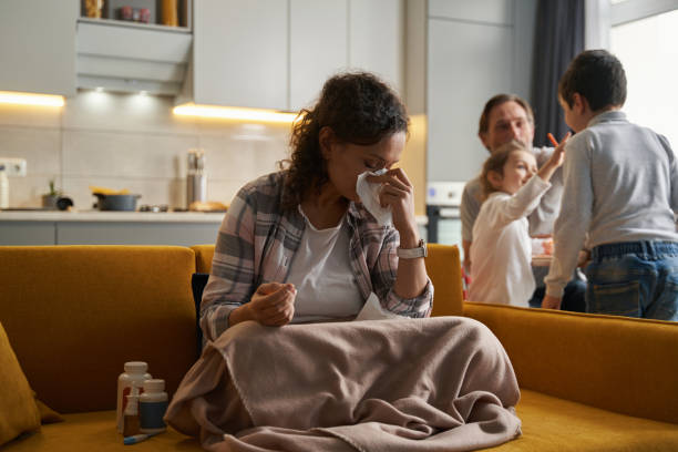 istock Young woman blowing her nose into napkin 1366618398