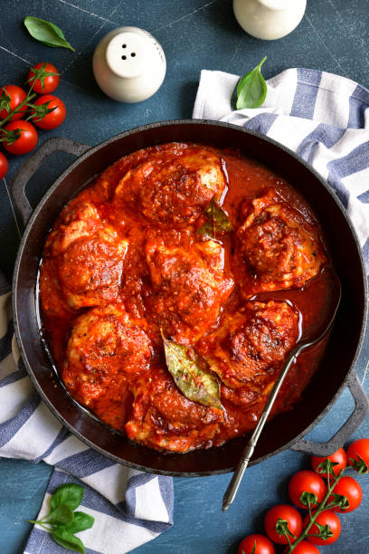 istock Chicken thighs stewed in tomato sauce. Top view with copy space. 1366619419