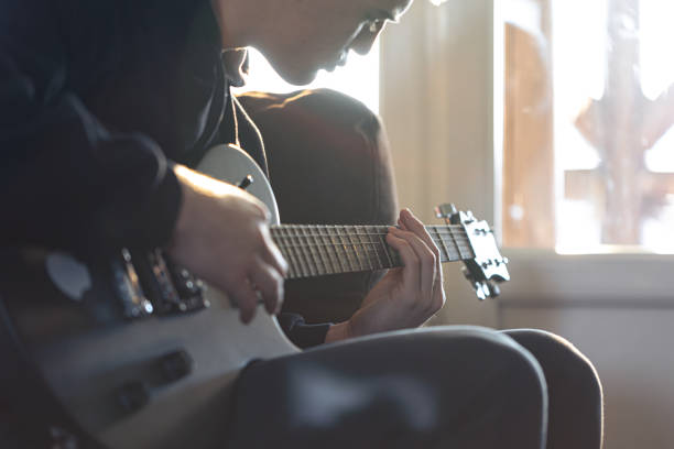 istock A young guy plays the electric guitar in his room. 1366619520