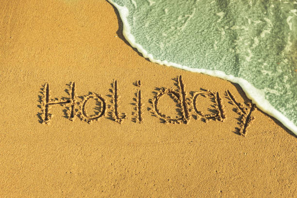 istock The word holiday written in the sand 1366620078