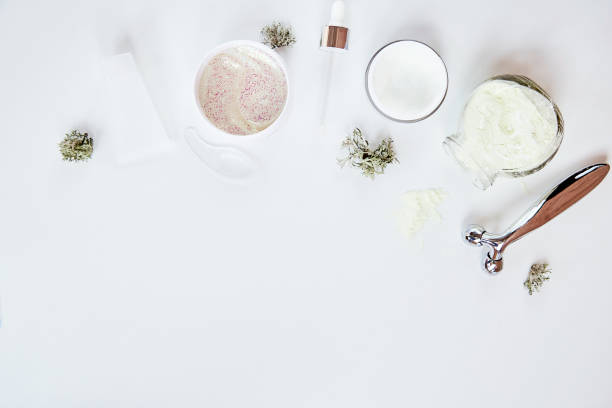 istock Wellness cosmetics on white background with copy space. Dermatology cosmetics. Face cream, alginate mask and massager. Natural eco forest moss decoration. Copy space 1366620618