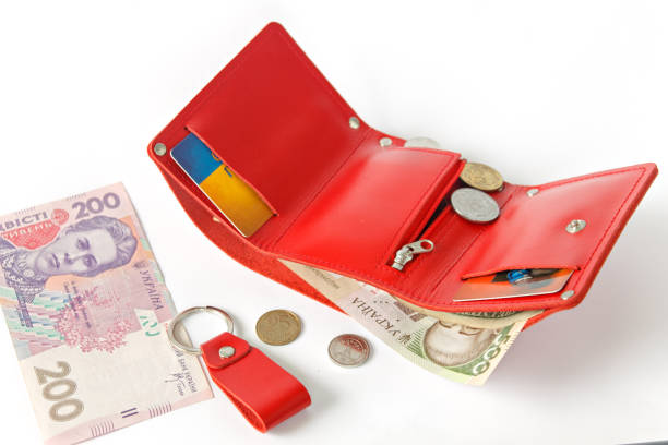 istock Leather bright red purse with money on a white background. Horizontal placement. Isolate. Ukrainian hryvnia. 1366620821