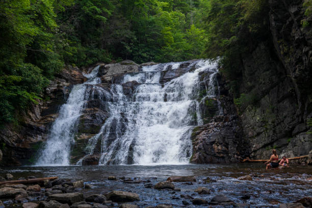 Laurel Falls in Carter County, Tennessee Three people enjoy the cool water at Laurel Falls near Hampton, Tennessee on July 11, 2021. johnson city tn stock pictures, royalty-free photos & images