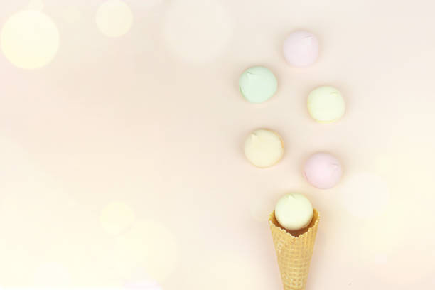 istock Waffle horn with colored marshmallow looks like macaroons on a pink pastel background. Top view. Free space for text. 1366622231