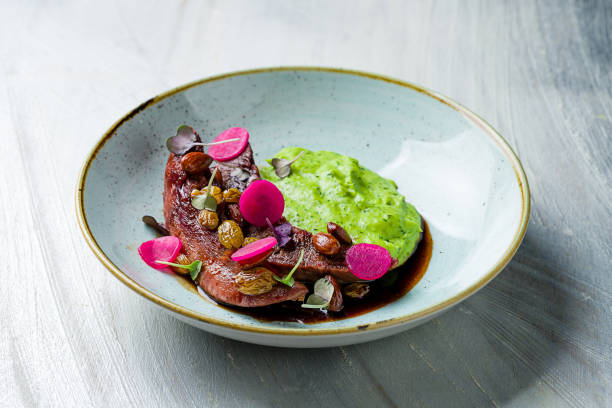 istock Duck breast with berry sauce mashed potatoes with spinach on grey table 1366623040