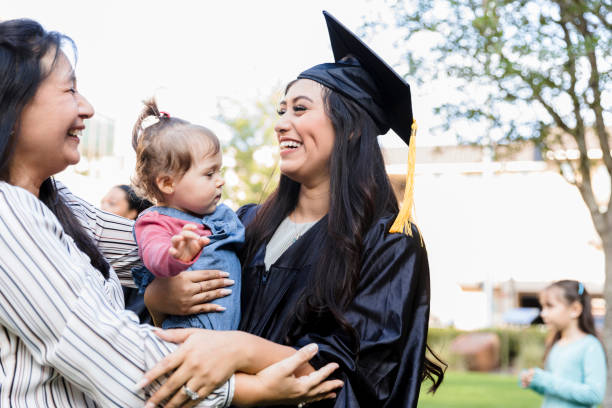 istock Three generations embrace after mid adult woman's graduation 1366623233