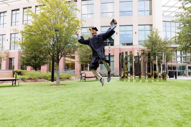 The mature adult man jumps in celebration after graduation
