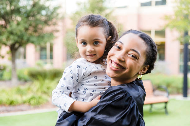 istock Graduate mother and young daughter smile for camera 1366623742