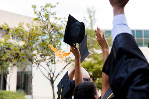 istock Diverse unrecognizable graduates raise hands to celebrate 1366623766