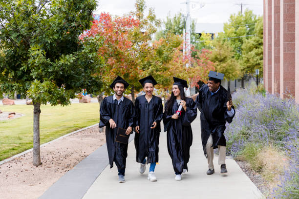 istock Four diverse friends walk and talk together after graduating 1366623778