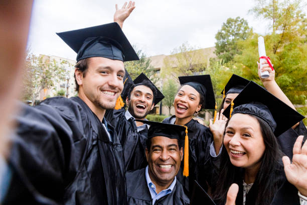 un groupe d’amis diversifiés prend une photo joyeuse après l’obtention du diplôme - remise de diplôme photos et images de collection