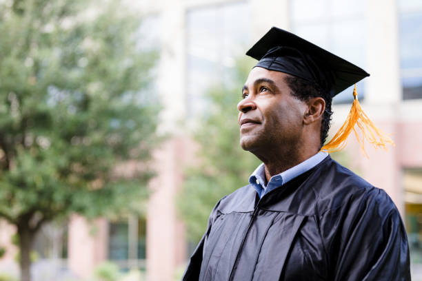 Mature adult man in cap and gown dreams of future