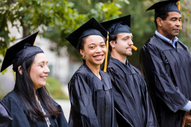 istock Woman standing with graduates smiles for camera 1366623886