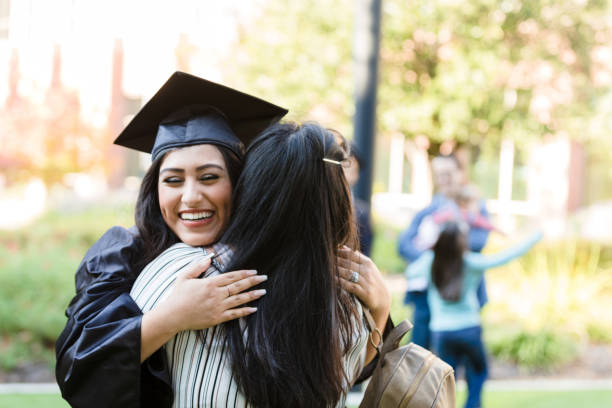 после окончания учебы дочь закрывает глаза, обнимая мать - mortar board child female people стоковые фото и изображения