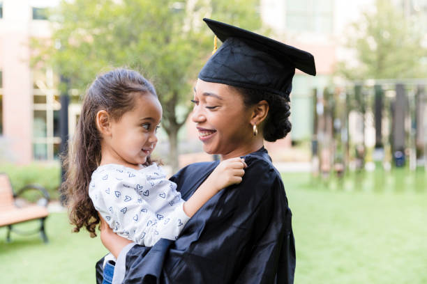 istock College graduate smiles at young daughter 1366624237