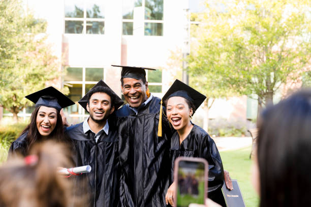 istock Group of four graduates poses for photos 1366624409