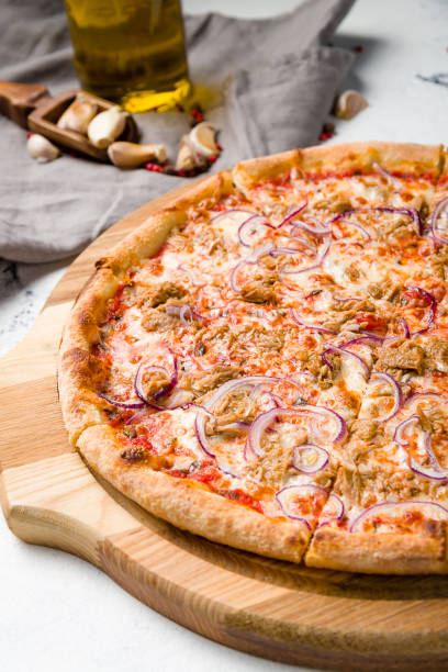 istock Pizza with tuna and red onion on the board on grey table macro close up 1366624530