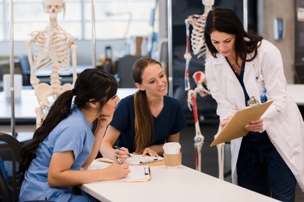 istock Female nursing students look at information teacher points out 1366626204