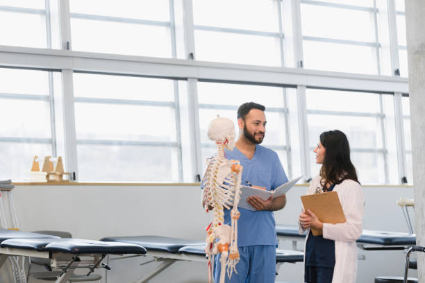 istock Medical student takes notes as professor talks about human skeleton 1366626378