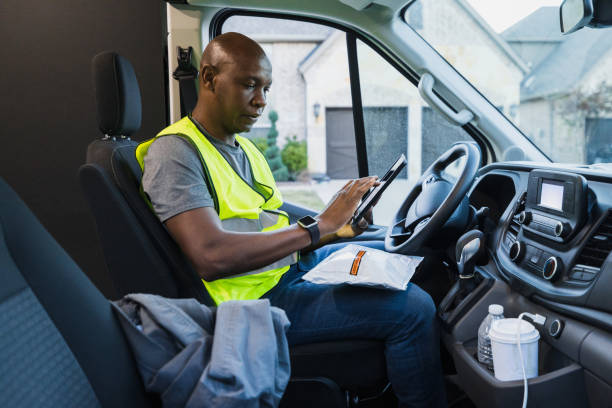 istock Male delivery driver uses tablet to confirm package address 1366627262