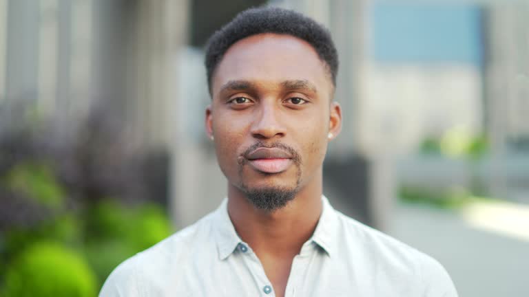 close up portrait serious African American man looking into the camera outside