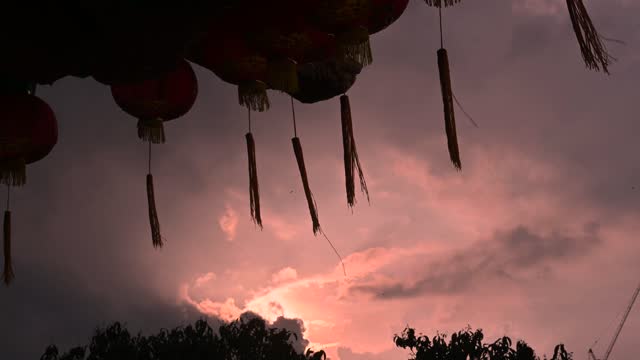 Round red lantern hanging on old traditional temple with beautiful sunrise
