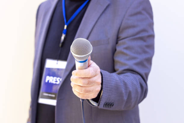 istock Journalist or news reporter holding microphone making media interview 1366632230