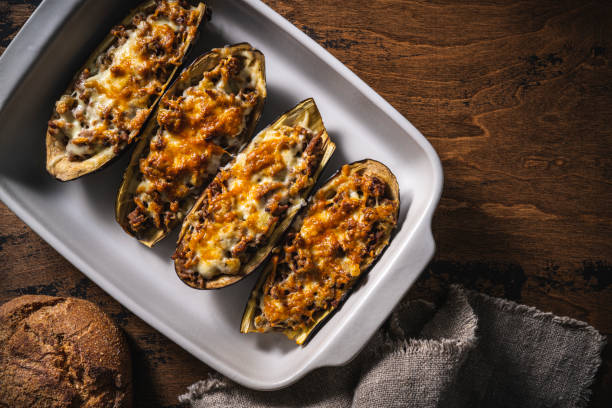 Stuffed Eggplants with minced meat recipe italian Aubergine Parmigiana or Eggplant parmesan Stuffed Eggplants with minced meat recipe italian Aubergine Parmigiana or Eggplant parmesan on rustic wood table in an oven tray Stuffing stock pictures, royalty-free photos & images