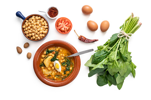 Potaje de garbanzos, chickpea stew spanish recipe vegetarian with spinach, potatoes and egg mediterranean diet isolated on white background