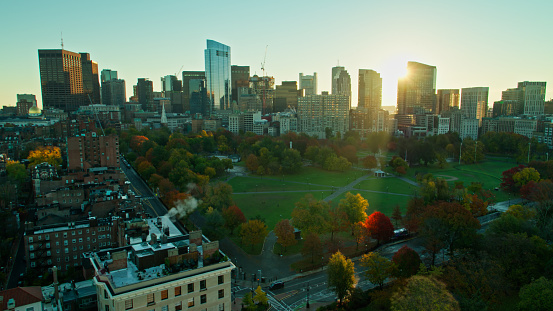 Aerial shot of Boston, Massachusetts at sunrise on a clear morning in Fall, looking across Boston Common towards the downtown skyscrapers. \n\nAuthorization was obtained from the FAA for this operation in restricted airspace.