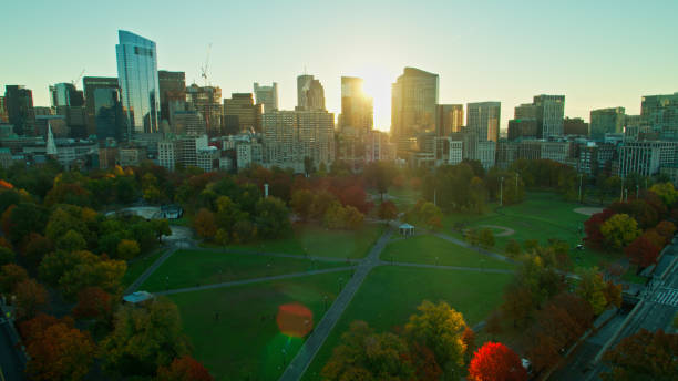 istock Sun Rising Between Downtown Skyscrapers Shining on Boston Common - Aerial 1366634772