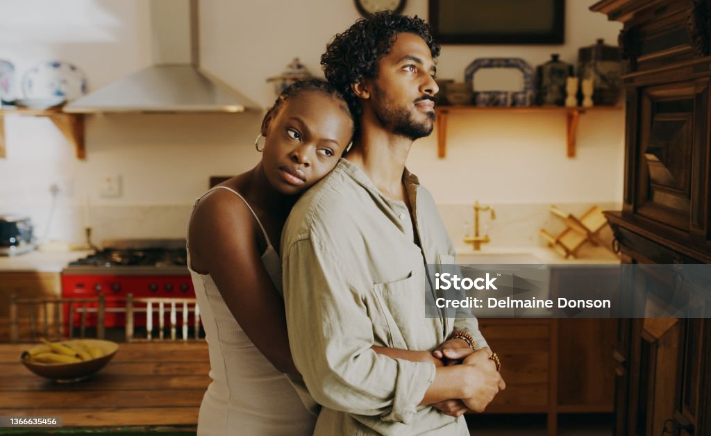 Shot of an attractive young woman hugging her boyfriend while bonding with him at home Please don't let this be the end Couple - Relationship Stock Photo
