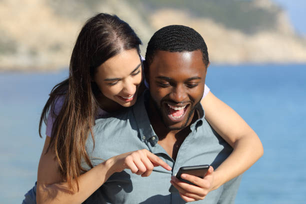 istock Interracial couple checking phone enjoying together 1366638415