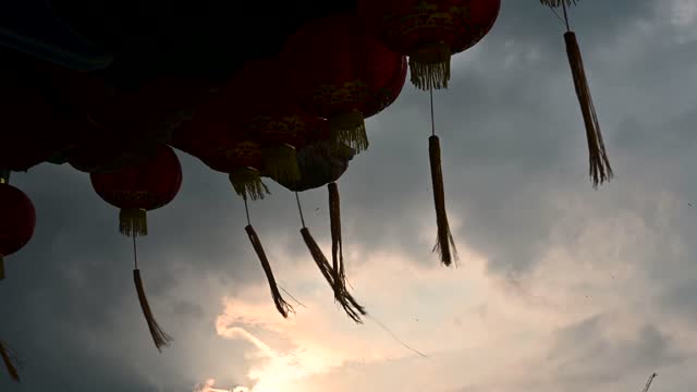 Round red lantern hanging on old traditional temple with beautiful sunrise