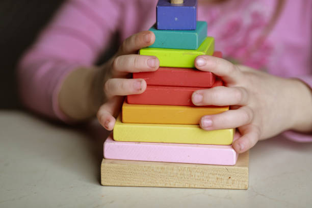 pyramide colorée assemblée par une fille - building block photos et images de collection