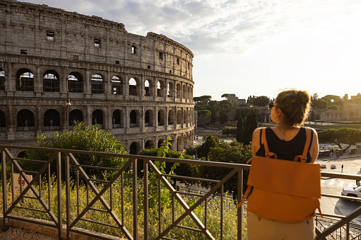 Young woman in Rome at the Colosseum looking at tourist map for directions; People travel capital cities of Europe concept