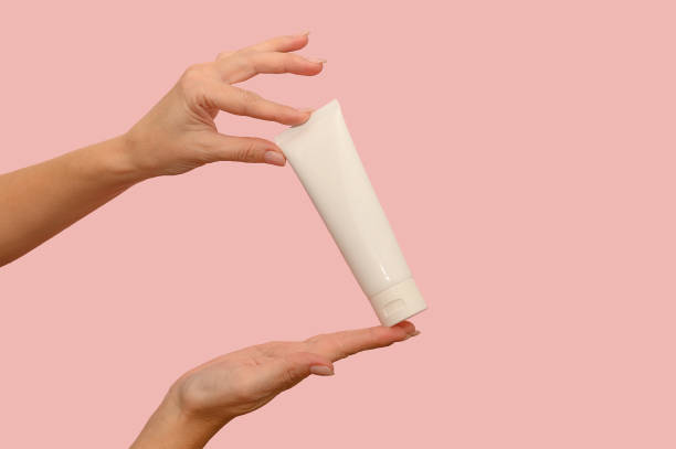 istock Hand holds a white container with cosmetic cream. For body care. 1366640488