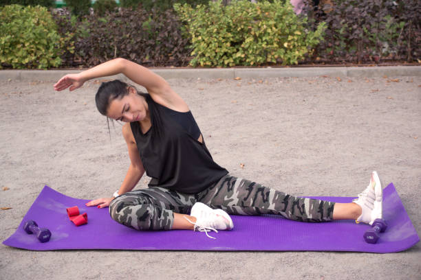 mulher forte fazendo flexões em halteres. mulheres musculosas estão se exercitando em um clube de saúde. esportes, estilo de vida saudável. - pilates women sit ups yoga - fotografias e filmes do acervo