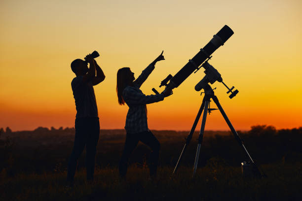istock Couple stargazing together with a astronomical telescope. 1366642774
