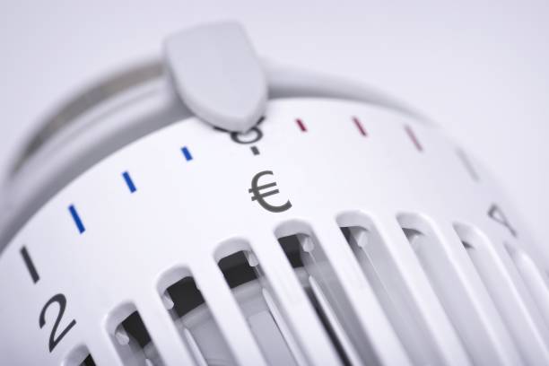termostato di un radiatore di riscaldamento con simbolo dell'euro, aumento dei costi per il concetto di calore ed energia. - fuel consumption foto e immagini stock
