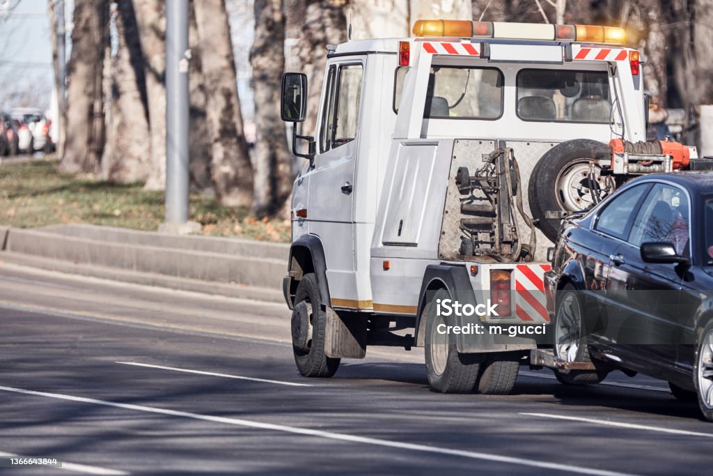 Tow truck carrying improperly parked car or repossesed vehicle. Tow Truck Stock Photo
