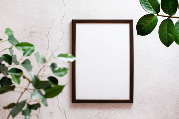 istock Eco mock up. Empty frame with a blank sheet on a light concrete background and leaves of home plants. Top view. 1366644171