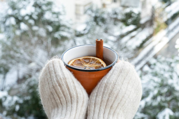 雪を見ながら冬のお茶を飲む - glove winter wool touching ストックフォトと画像