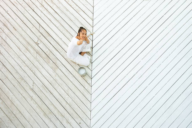 istock Above view smiling asian woman painting deck 1366646893