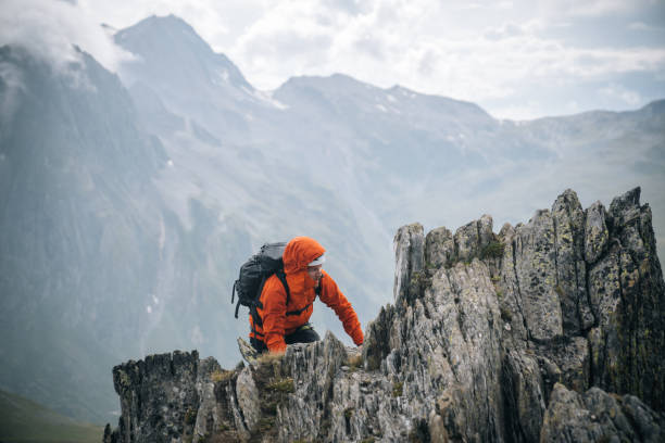 istock Mountaineer scrambles up mountain ridge 1366647334